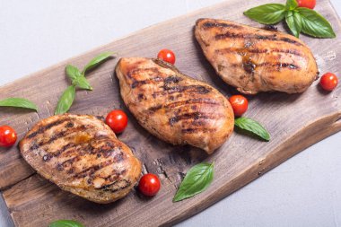 Izgara tavuk göğsü (fileto) fesleğen ve domates ile. Barbekü arka plan