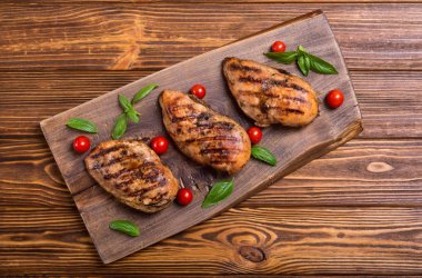 Izgara tavuk göğsü (fileto) fesleğen ve domates ile. Barbekü arka plan
