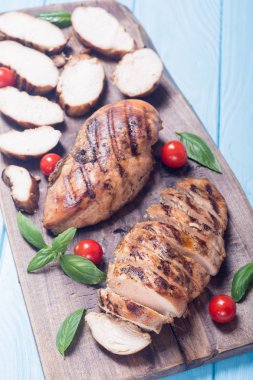 Izgara tavuk göğsü (fileto) fesleğen ve domates ile. Barbekü arka plan