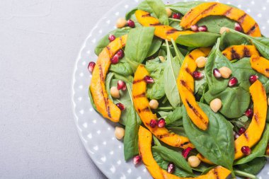 Kabak, ıspanak, nar ve nohut sonbahar salatası. Sağlıklı vegan gıda