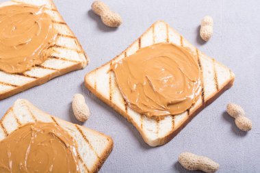 Fıstık ezmeli sandviç ya da ahşap arka planda tost.