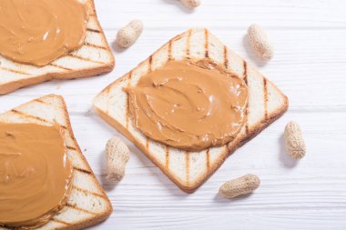 Fıstık ezmeli sandviç ya da ahşap arka planda tost.