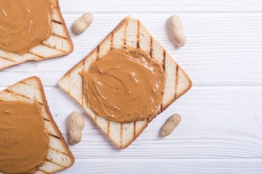 Fıstık ezmeli sandviç ya da ahşap arka planda tost.