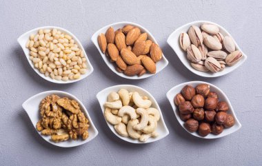 Fındık karışımı: antep fıstığı, badem, ceviz, çam fıstığı, fındık ve kaju. Kase backgrond içinde snack