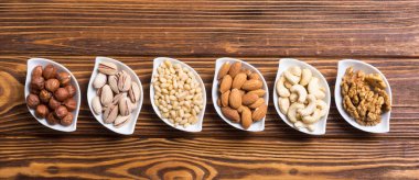 Fındık karışımı: antep fıstığı, badem, ceviz, çam fıstığı, fındık ve kaju. Kase backgrond içinde snack