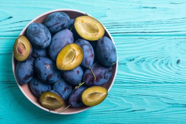 Ahşap masa üzerinde kase taze erik. Meyve arka plan