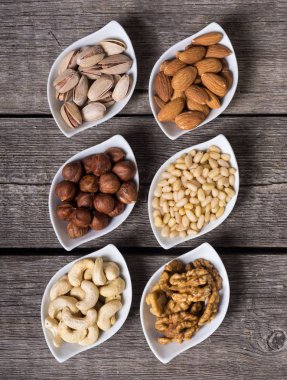 Fındık karışımı: antep fıstığı, badem, ceviz, çam fıstığı, fındık ve kaju. Kase backgrond içinde snack