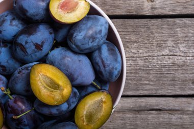 Ahşap masa üzerinde kase taze erik. Meyve arka plan