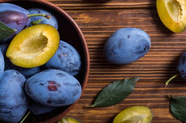 Ahşap masa üzerinde kase taze erik. Meyve arka plan