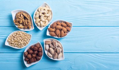 Fındık karışımı: antep fıstığı, badem, ceviz, çam fıstığı, fındık ve kaju. Kase backgrond içinde snack