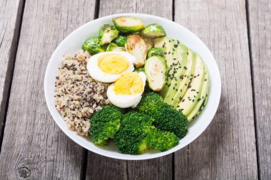 Quinoa, yumurta, avokado, Brüksel lahanası ve brokoli ile Buda kase. Ahşap backggroun yiyecek vegan salataya