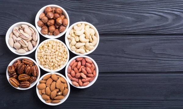 Fındık karışımı: antep fıstığı, badem, ceviz, çam fıstığı, fındık ve kaju. Kase backgrond içinde snack