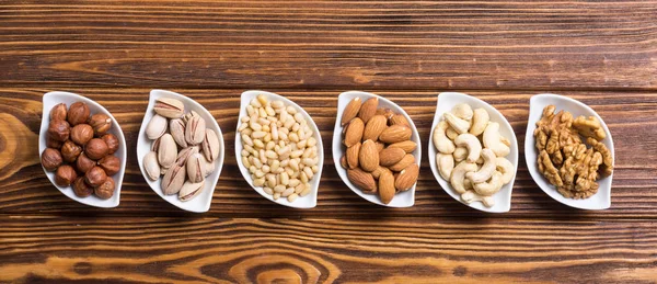 Fındık karışımı: antep fıstığı, badem, ceviz, çam fıstığı, fındık ve kaju. Kase backgrond içinde snack