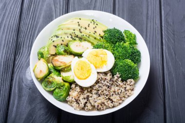 Quinoa, yumurta, avokado, Brüksel lahanası ve brokoli ile Buda kase. Ahşap backggroun yiyecek vegan salataya