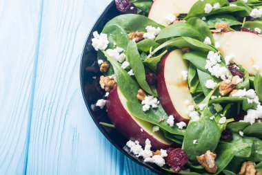 Elma, peynir, ceviz ve kurutulmuş kızılcık sonbahar ıspanak salatası. Sağlıklı vejetaryen yemek