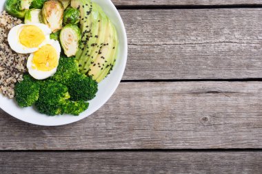 Quinoa, yumurta, avokado, Brüksel lahanası ve brokoli ile Buda kase. Ahşap backggroun yiyecek vegan salataya