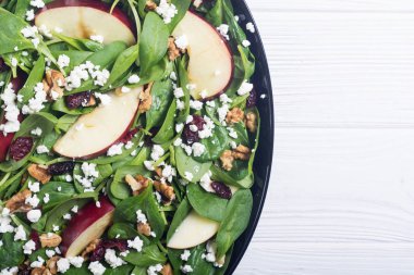 Elma, peynir, ceviz ve kurutulmuş kızılcık sonbahar ıspanak salatası. Sağlıklı vejetaryen yemek