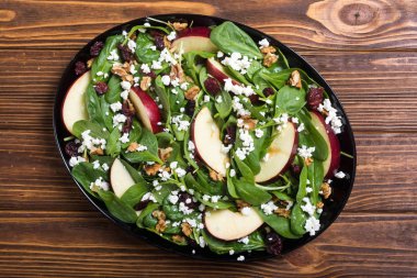 Elma, peynir, ceviz ve kurutulmuş kızılcık sonbahar ıspanak salatası. Sağlıklı vejetaryen yemek