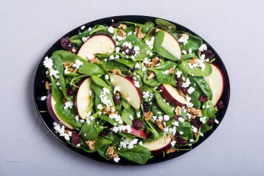 Elma, peynir, ceviz ve kurutulmuş kızılcık sonbahar ıspanak salatası. Sağlıklı vejetaryen yemek