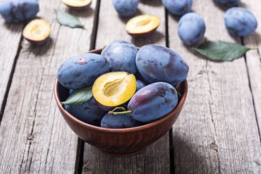 Ahşap masa üzerinde kase taze erik. Meyve arka plan