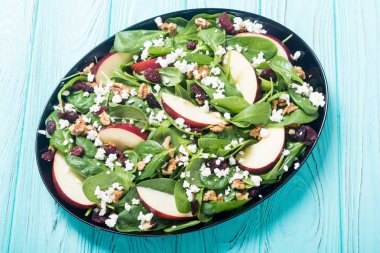 Elma, peynir, ceviz ve kurutulmuş kızılcık sonbahar ıspanak salatası. Sağlıklı vejetaryen yemek