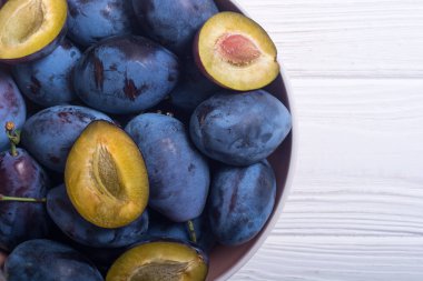 Ahşap masa üzerinde kase taze erik. Meyve arka plan