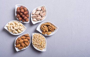 Fındık karışımı: antep fıstığı, badem, ceviz, çam fıstığı, fındık ve kaju. Kase backgrond içinde snack