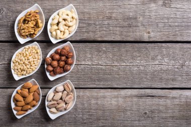 Fındık karışımı: antep fıstığı, badem, ceviz, çam fıstığı, fındık ve kaju. Kase backgrond içinde snack