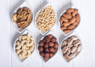 Fındık karışımı: antep fıstığı, badem, ceviz, çam fıstığı, fındık ve kaju. Kase backgrond içinde snack