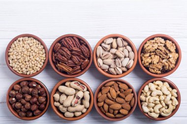 Fındık karışımı: antep fıstığı, badem, ceviz, çam fıstığı, fındık ve kaju. Kase backgrond içinde snack