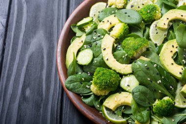 Yeşil bebek ıspanak salatası avokado, brokoli, salatalık, kireç ve susam. Sağlıklı detoks vegan gıda