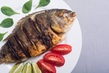 Kızarmış balık dorado limon, domates ve ıspanak ile. Deniz gıda arka plan