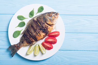 Kızarmış balık dorado limon, domates ve ıspanak ile. Deniz gıda arka plan