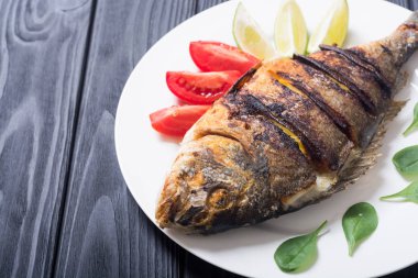 Kızarmış balık dorado limon, domates ve ıspanak ile. Deniz gıda arka plan