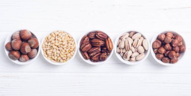 Fındık karışımı: antep fıstığı, badem, ceviz, çam fıstığı, fındık ve kaju. Kase backgrond içinde snack