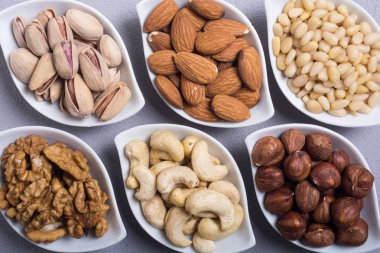 Fındık karışımı: antep fıstığı, badem, ceviz, çam fıstığı, fındık ve kaju. Kase backgrond içinde snack