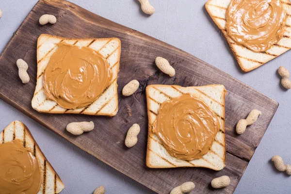 Peanut butter sandwiches or toasts on wooden background