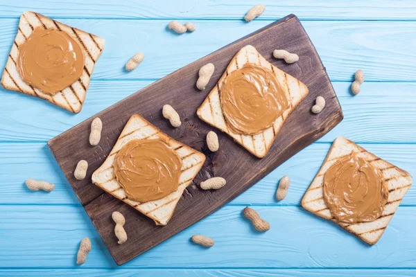 Peanut butter sandwiches or toasts on wooden background