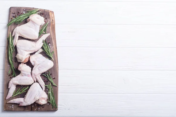 Chicken raw wings with rosemary , garlic , pepper and salt . Ingredient for preparation