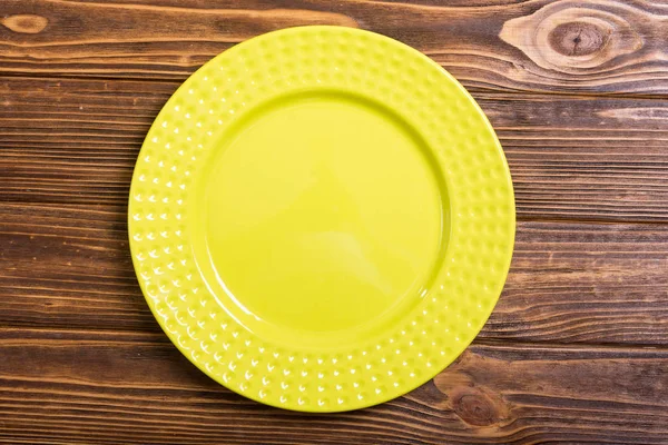 空的黄色盘子在木桌上 顶部视图背景 — 图库照片