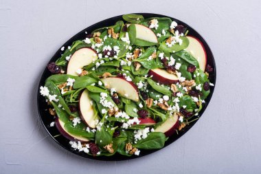 Elma, peynir, ceviz ve kurutulmuş kızılcık sonbahar ıspanak salatası. Sağlıklı vejetaryen yemek