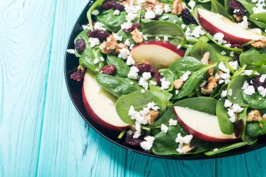 Elma, peynir, ceviz ve kurutulmuş kızılcık sonbahar ıspanak salatası. Sağlıklı vejetaryen yemek