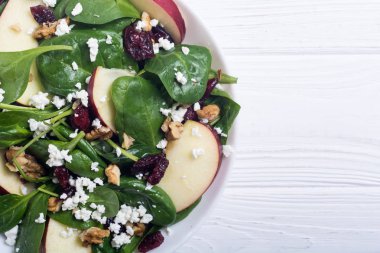 Elma, peynir, ceviz ve kurutulmuş kızılcık sonbahar ıspanak salatası. Sağlıklı vejetaryen yemek