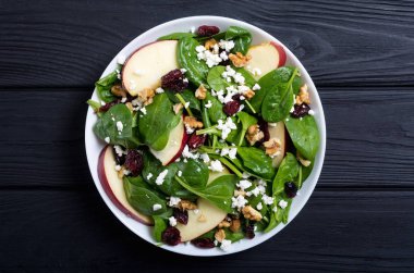 Elma, peynir, ceviz ve kurutulmuş kızılcık sonbahar ıspanak salatası. Sağlıklı vejetaryen yemek