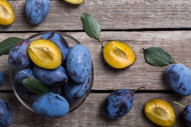 Ahşap masa üzerinde kase taze erik. Meyve arka plan