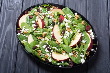 Elma, peynir, ceviz ve kurutulmuş kızılcık sonbahar ıspanak salatası. Sağlıklı vejetaryen yemek