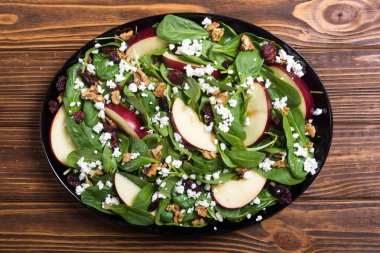 Elma, peynir, ceviz ve kurutulmuş kızılcık sonbahar ıspanak salatası. Sağlıklı vejetaryen yemek