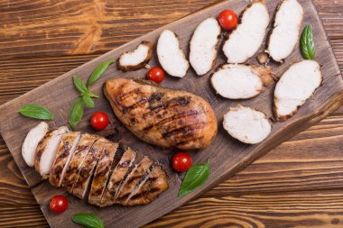 Izgara tavuk göğsü (fileto) fesleğen ve domates ile. Barbekü arka plan