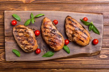 Izgara tavuk göğsü (fileto) fesleğen ve domates ile. Barbekü arka plan