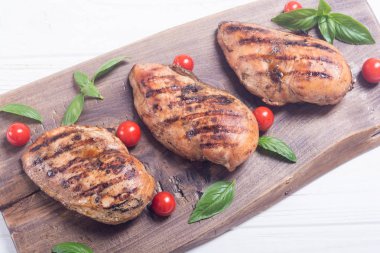 Izgara tavuk göğsü (fileto) fesleğen ve domates ile. Barbekü arka plan